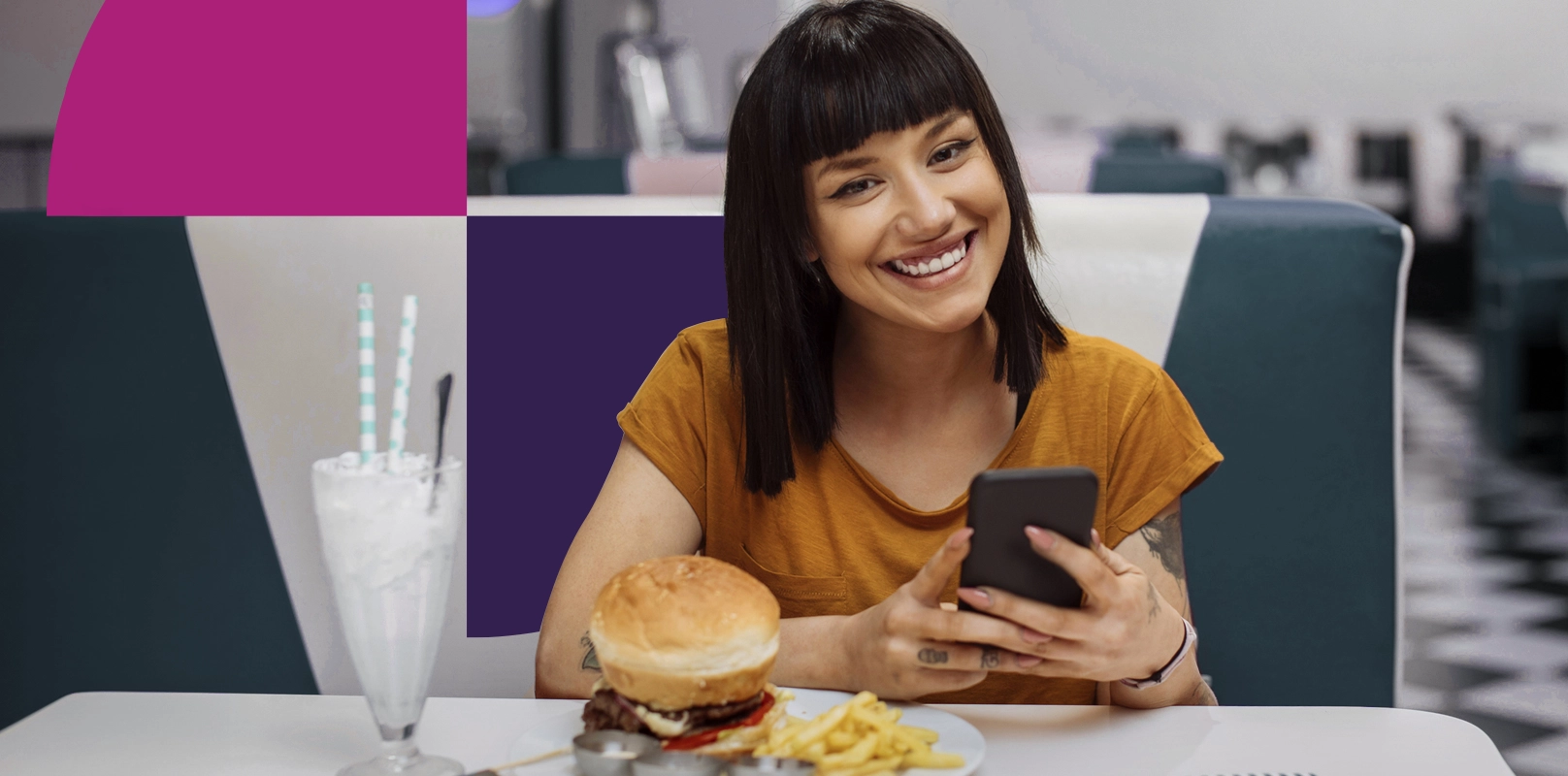 Woman smiling while checking her Saven accounts in a restaurant